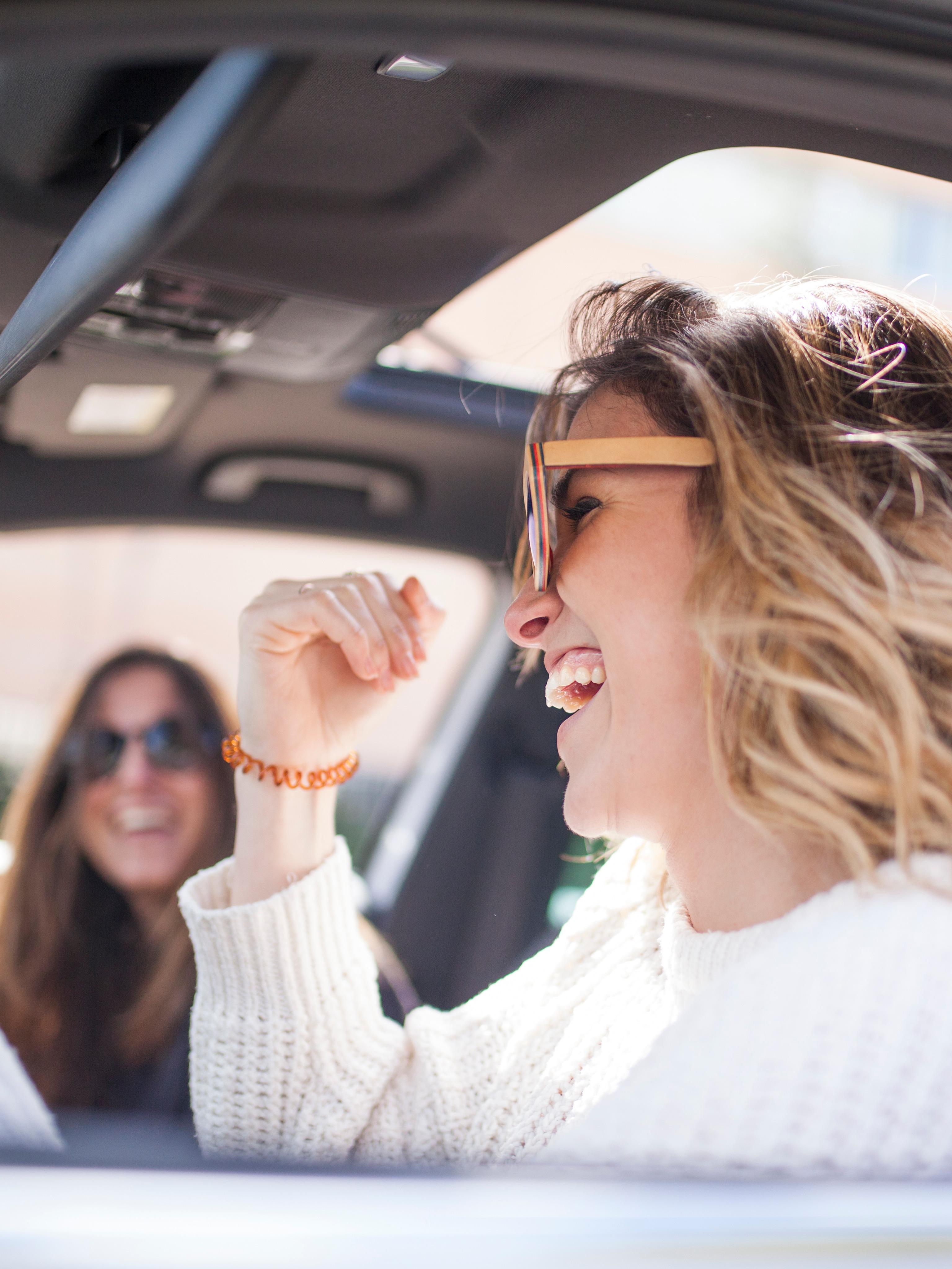 Zwei Frau lachen in einem Auto