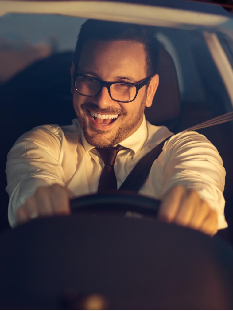 Mann freut sich hinter dem Lenkrad im Auto